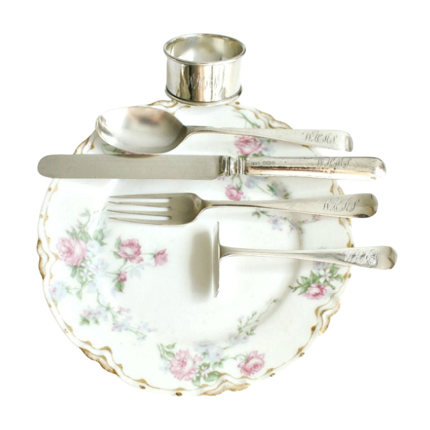 English sterling silver child’s christening set with napkin ring, fork, spoon, knife, and floral plate—an exquisite heirloom gift in its original case.