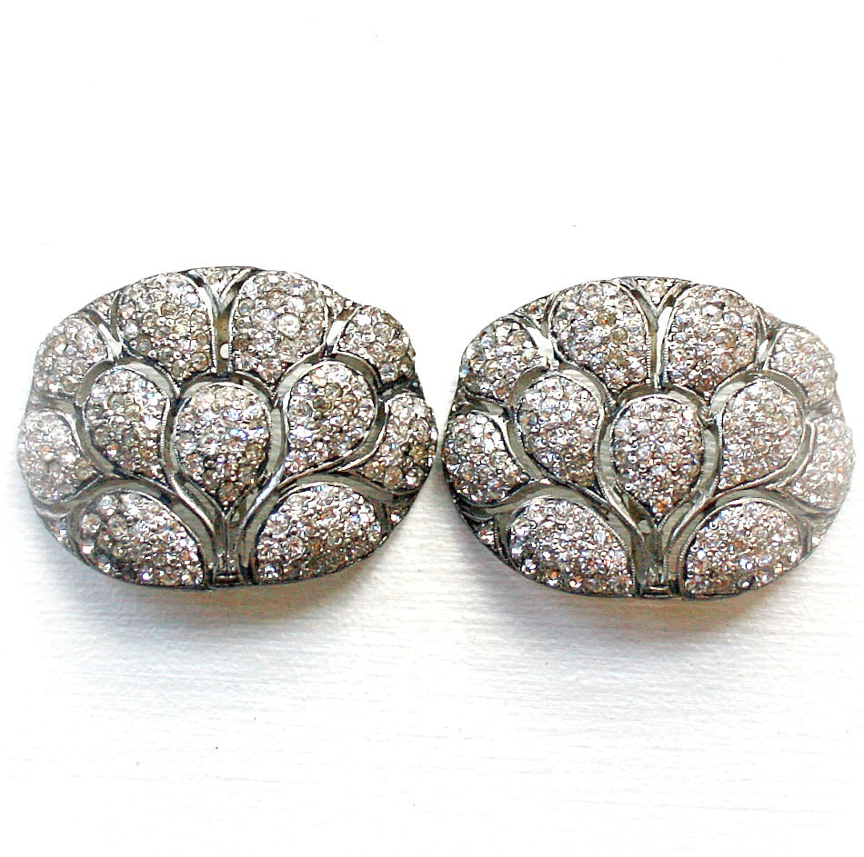 A pair of vintage, rhinestone-encrusted shoe buckles with a geometric, peacock-like pattern, domed and plated in rhodium.
