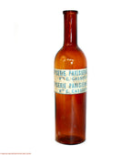 Close detail of antique amber glass bottles with rich patina and glow and paper label