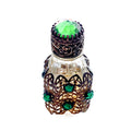 Exquisite Art Deco miniature perfume bottle adorned with emerald glass jewels and intricate gilt filigree. A romantic collector’s treasure of timeless elegance.