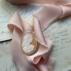 Hand carved shell cameo brooch with classical female portrait, antique style jewelry in unmarked gold setting, refined collectible estate piece. on pink silk french ribbon