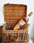 Antique French champagne basket with handles a bottle of Lillet and baguette