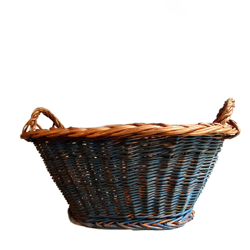 Handwoven vintage Dutch wicker basket showing faded Delft painted finish and tactile weave texture