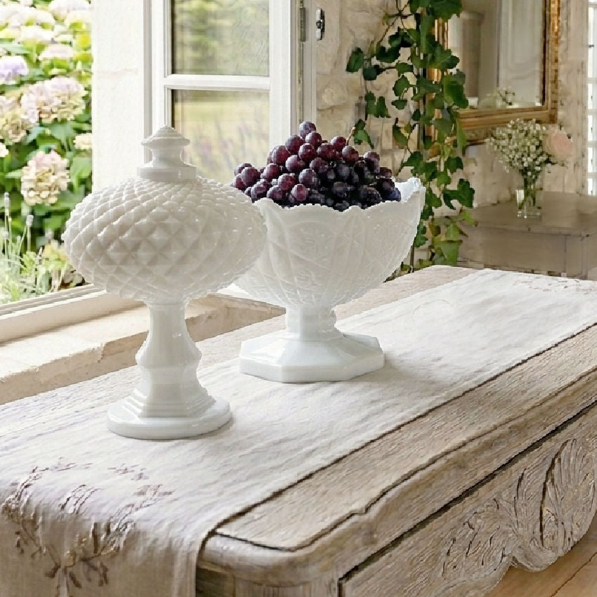 white milk glass pedestal serving bowl decorative table object holding grapes