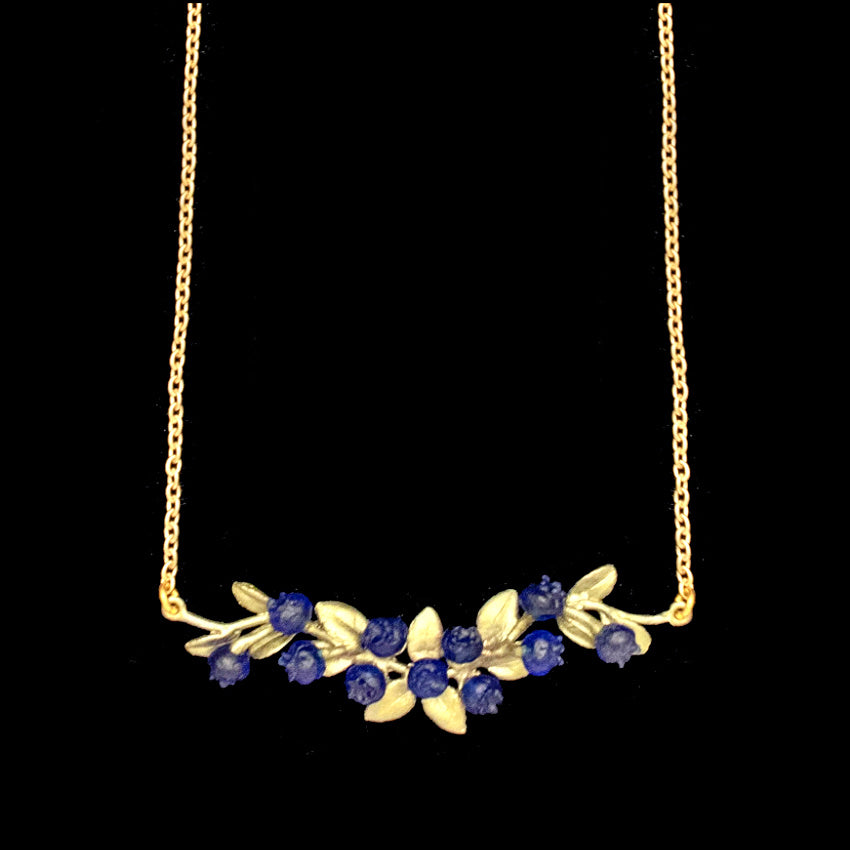 Blueberry bar necklace in patinated bronze, horizontal botanical berry pendant with nature-inspired detail, perfect for modern layered jewelry styling close up uf hand made glass blueberries and gold chain
