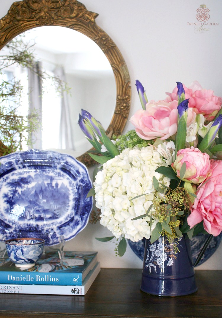 blue and white on a mantel with pink peonies