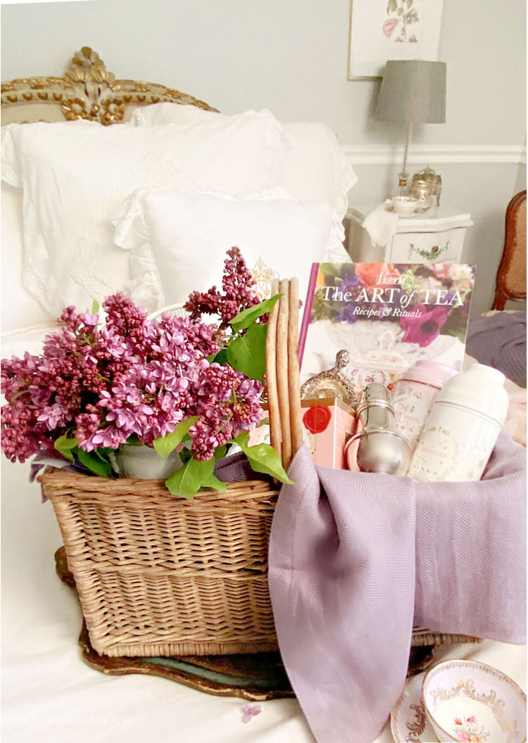 lilacs in a basket filled with tea party things